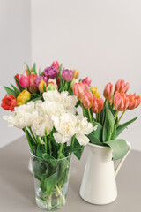 Lovely bouquets of tulips in vases on the table.