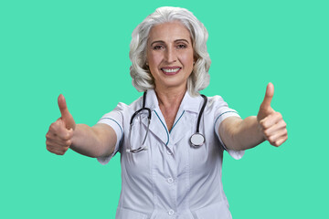 Beautiful happy woman doctor giving thumb up sign with both hands. Female doctor gesturing thumbs...