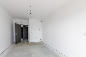 New empty room under construction. Plaster walls. New home. Concrete walls. Interior renovation.