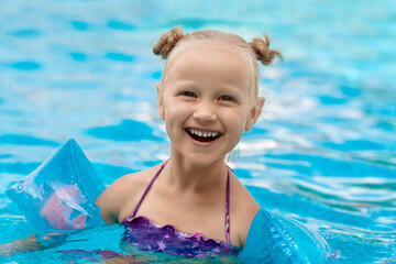 Pool Summer Vacation. Happy Smilling Little Girl have fun playing in Pool. Aqua park for Children.