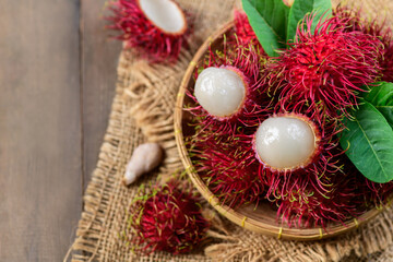 Top view of Fresh Rambutan fruits with leaves on bamboo basket