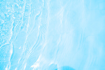 Fototapeta na wymiar Blurred transparent blue colored clear calm water surface texture with splashes and bubbles. Trendy abstract nature background. Water waves in sunlight. water background