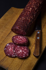 Raw smoked sausage on a black background. Sliced sausage on a black background. meat product