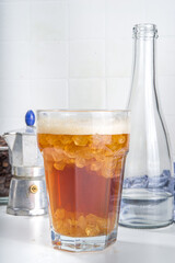 Fizzy coffee drink. Coffee espresso with carbonated mineral water and crushed ice, with coffee maker, milk roasted coffee beans on white background copy space