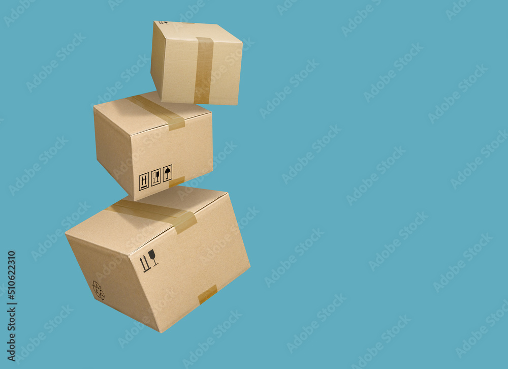 Wall mural Cardboard parcel boxes falling on turquoise blue background