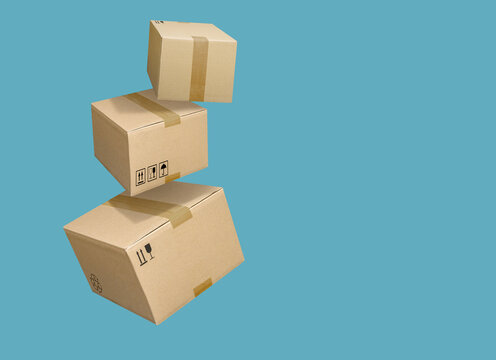 Cardboard parcel boxes falling on turquoise blue background