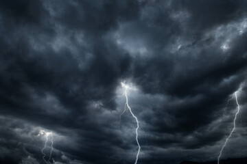 Thunderous dark sky with black clouds and flashing lightning. Panoramic view. Concept on the theme...