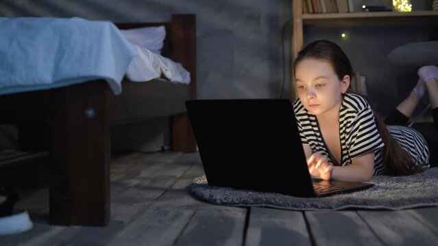 Prodigy kid hacker programmer at data center with monitor screen. Children using digital devices. girl little student with a laptop at evening at home, children and technology