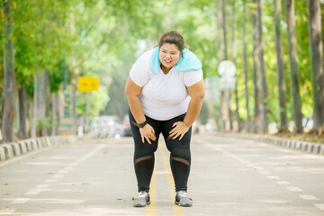 Overweight woman catching breath after running
