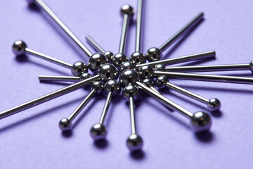 Piercing earrings close-up. On a Violet background.