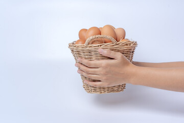 Hand holding a basket of eggs on a white background. A gift for a special day during the Heater season. healthy food protein