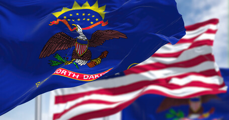 The North Dakota state flag waving along with the national flag of the United States of America