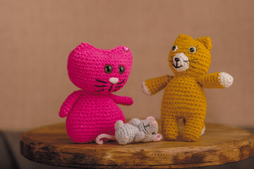 Amigurumi handmade dolls 2 cats and a mouse. The background is brown.