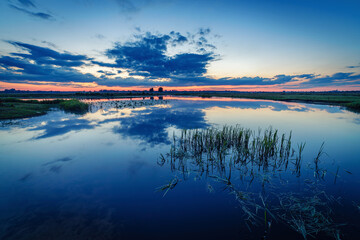 Moody sunset over calm lake