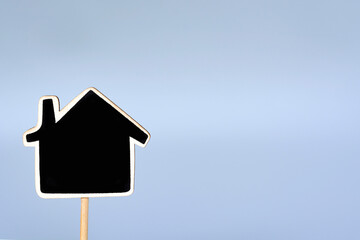 Wooden house model against blue background. Business and real estate concept.