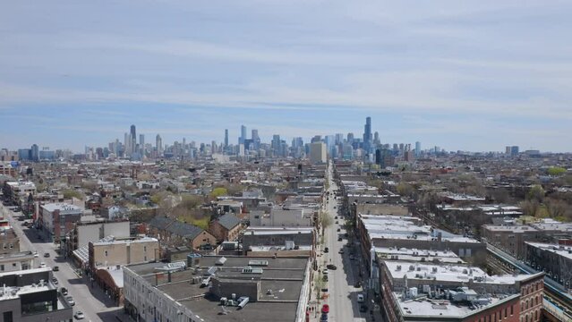 Several Cars Drive On W North Ave Past A Tall Hotel Just Next To The Damen Metro Station Overlooking The Chicago Skyline With The Willis Tower On A Sunny Day. Backwards Drone Dolly Shot