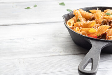 Baked pasta with meat, tomatoes, basil leaves and red pepper. Top view with copy space