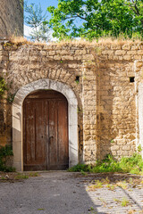 Old worn-out doors in a historic stone house of the 18th-19th centuries. Travel to European cities, southern Italy, old retro architecture