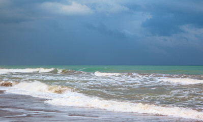 Dramatic powerful sea waves crashing sandy beach