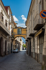 Narrow historic (medieval) streets of a small town in southern Italy. Old stone houses, wooden windows and doors, cobblestone road.