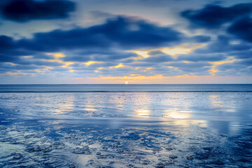 Fototapeta premium Beach at sunset (mud flat ) me passing clouds at mudflats