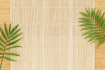 Eco friendly, wooden background. Empty wooden board with natural mat and palm leaves, flat lay....