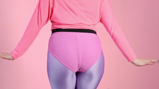 Funny reto fitness. Female butt in leggings doing fitness aerobics exercises. Athlete workout from the 80's. Vintage aerobic 80s 90s style. Stupid-looking. Booty shake	
