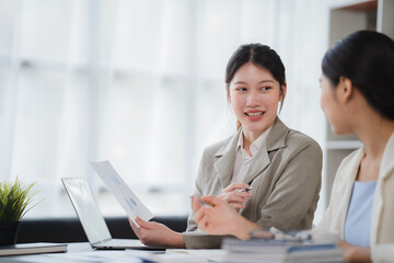 Obraz premium Two Businesswomen Having Informal Meeting In Modern Office, mentor helping apprentice explain corporate program, support teamwork concept.