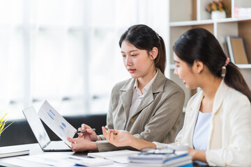 Fototapeta premium Two Businesswomen Having Informal Meeting In Modern Office, mentor helping apprentice explain corporate program, support teamwork concept.