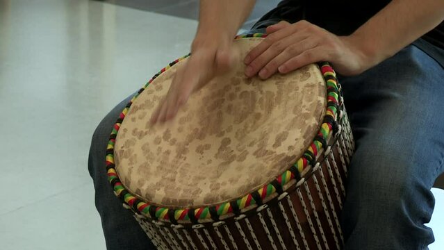 Hands of a musician playing a djembe, a percussion instrument, a type of drum originally from Guinea in West Africa.
