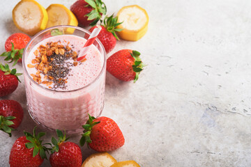 Strawberry smoothie. Vegan smoothie or milkshake from strawberry, banana and mint on white wooden...