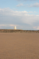 Lone lighthouse with an empty beach in the foreground