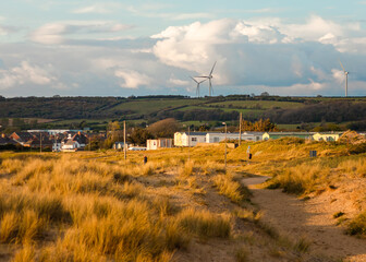 Cloudy day with wind mills and wind swept brush 