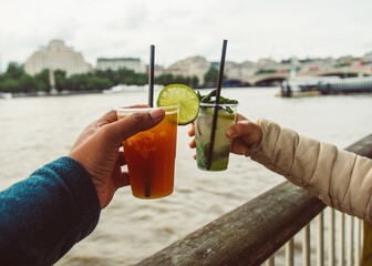 persons holding  cocktails with city in background