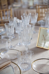Hall of an ancient castle with catering for wedding events. The tables are set up with fine plates, glasses and cutlery