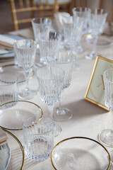 Hall of an ancient castle with catering for wedding events. The tables are set up with fine plates, glasses and cutlery