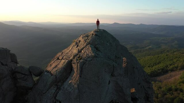 Traveler Reaching Top of Mountain and Hands Raising in a Sunset Light.