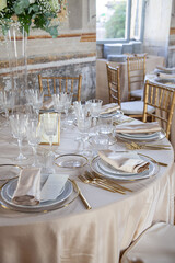 Hall of an ancient castle with catering for wedding events. The tables are set up with fine plates, glasses and cutlery