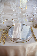 Hall of an ancient castle with catering for wedding events. The tables are set up with fine plates, glasses and cutlery