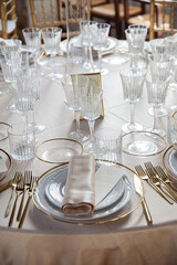Hall of an ancient castle with catering for wedding events. The tables are set up with fine plates, glasses and cutlery
