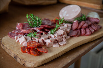 Cutting board with variety of typical Italian cold cuts and meats placed on the preparation table during a catering event
