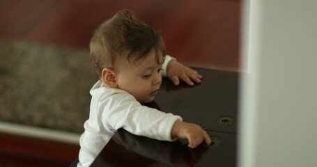 Naklejka premium Cute baby leaning home furniture playing with table top