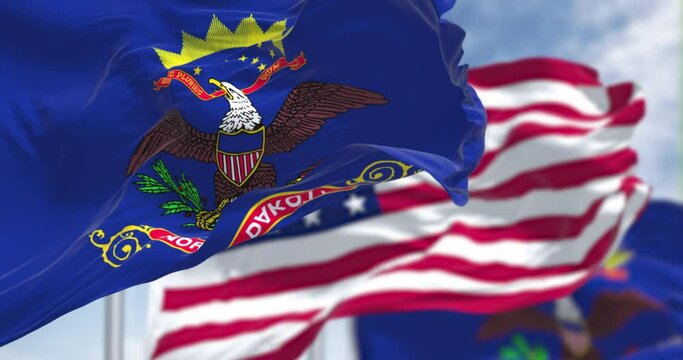 The North Dakota state flag waving along with the national flag of the US