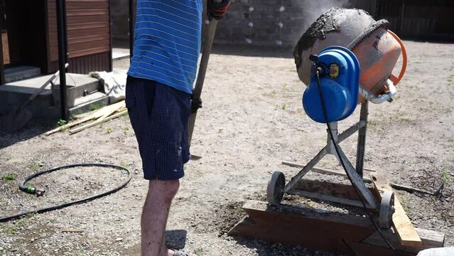 mixing concrete. a man works with a concrete mixer. do-it-yourself construction work.