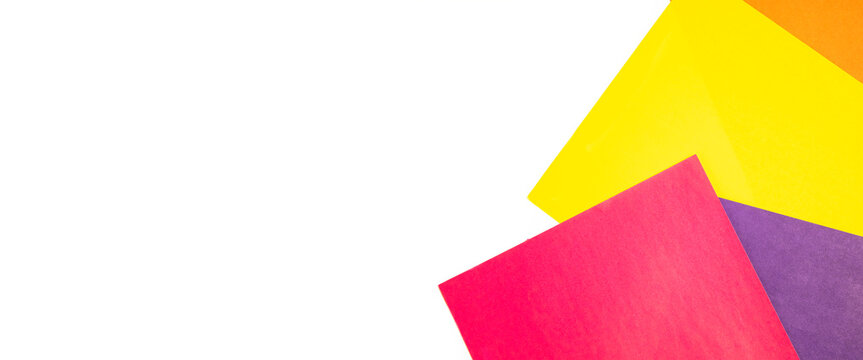 Colored paper on white background. Top view, flat lay. Banner
