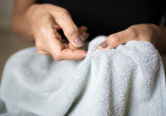 A picture of a woman's hand doing a sewing activity with traditional craftsmanship.