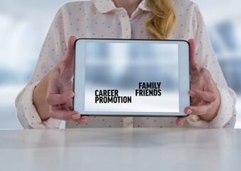 Mid section of woman holding a digital tablet with career, promotion, family and friends texts