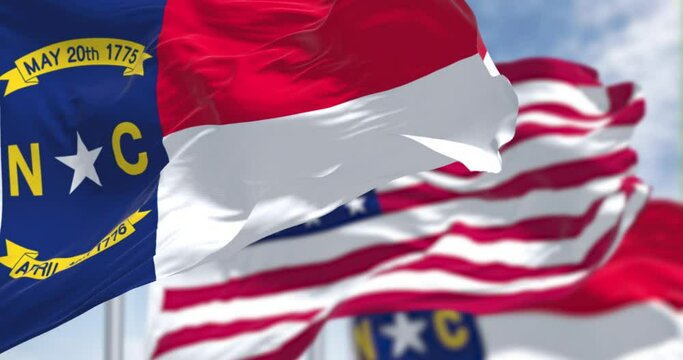 The North Carolina state flag waving along with the national flag of the US