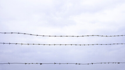 barbed wire against a cloudy sky
