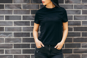 Stylish brunette asian girl wearing black t-shirt posing against street , urban clothing style. Street photography - Powered by Adobe